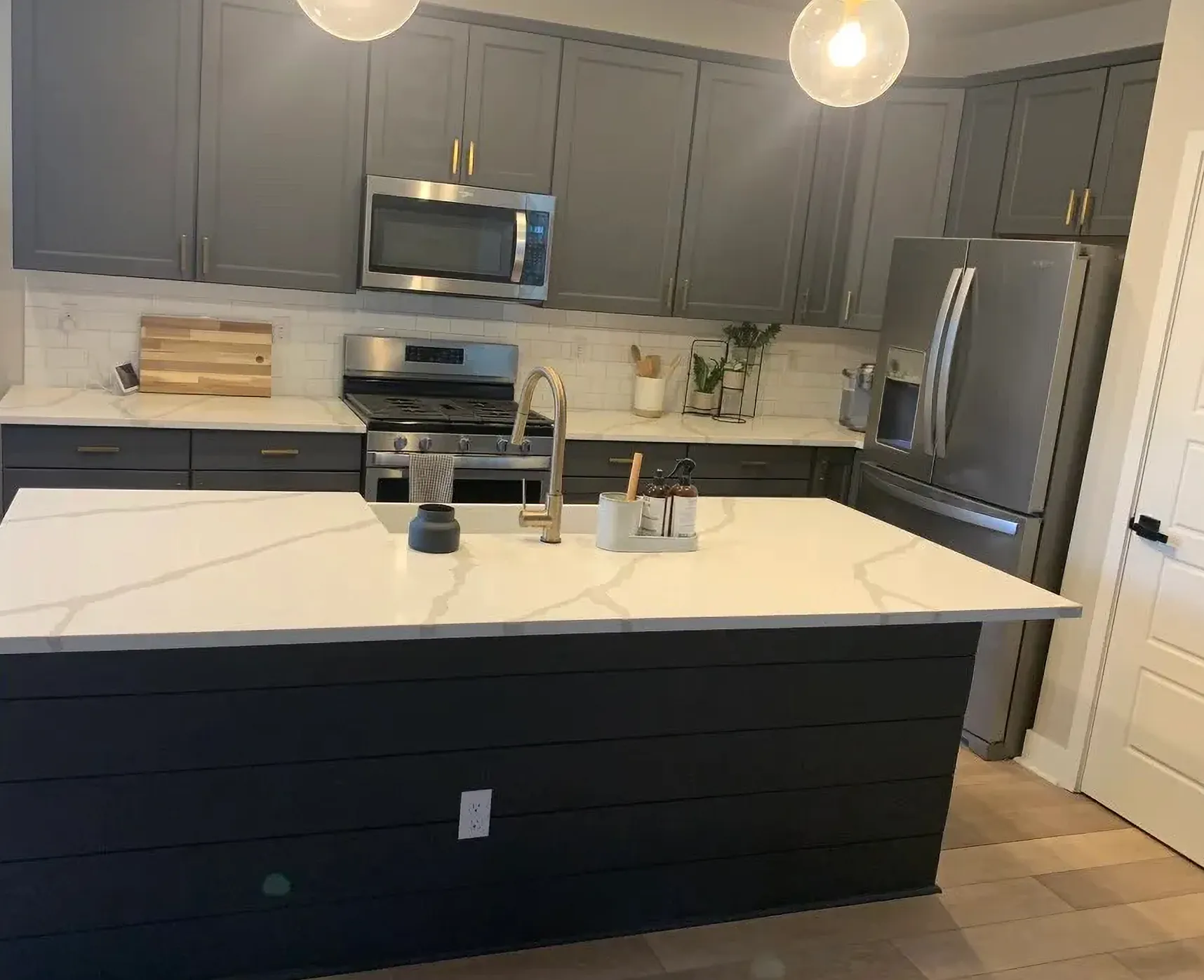 Modern kitchen renovation featuring a waterfall quartz island