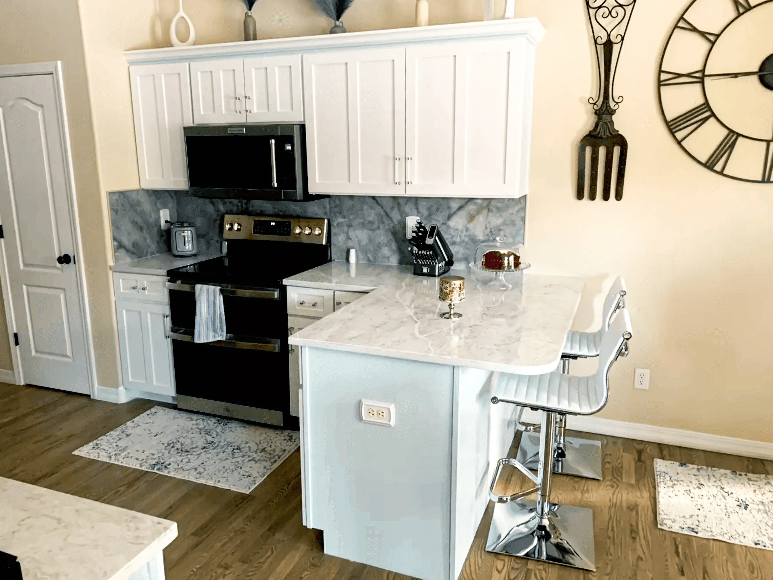 Designer kitchen island with white cabinets and marble-style quartz