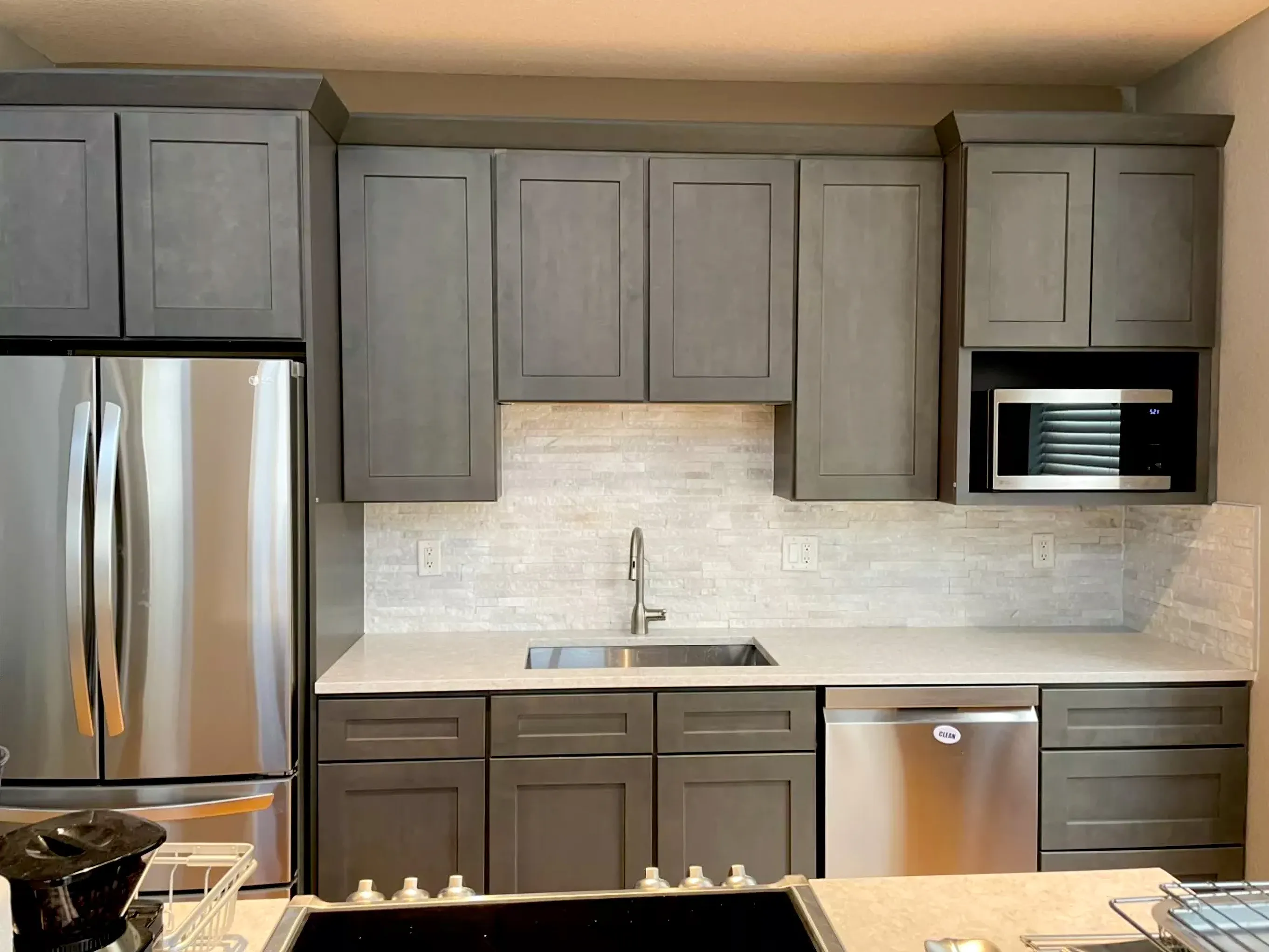 Contemporary kitchen with dark grey cabinets and light quartz