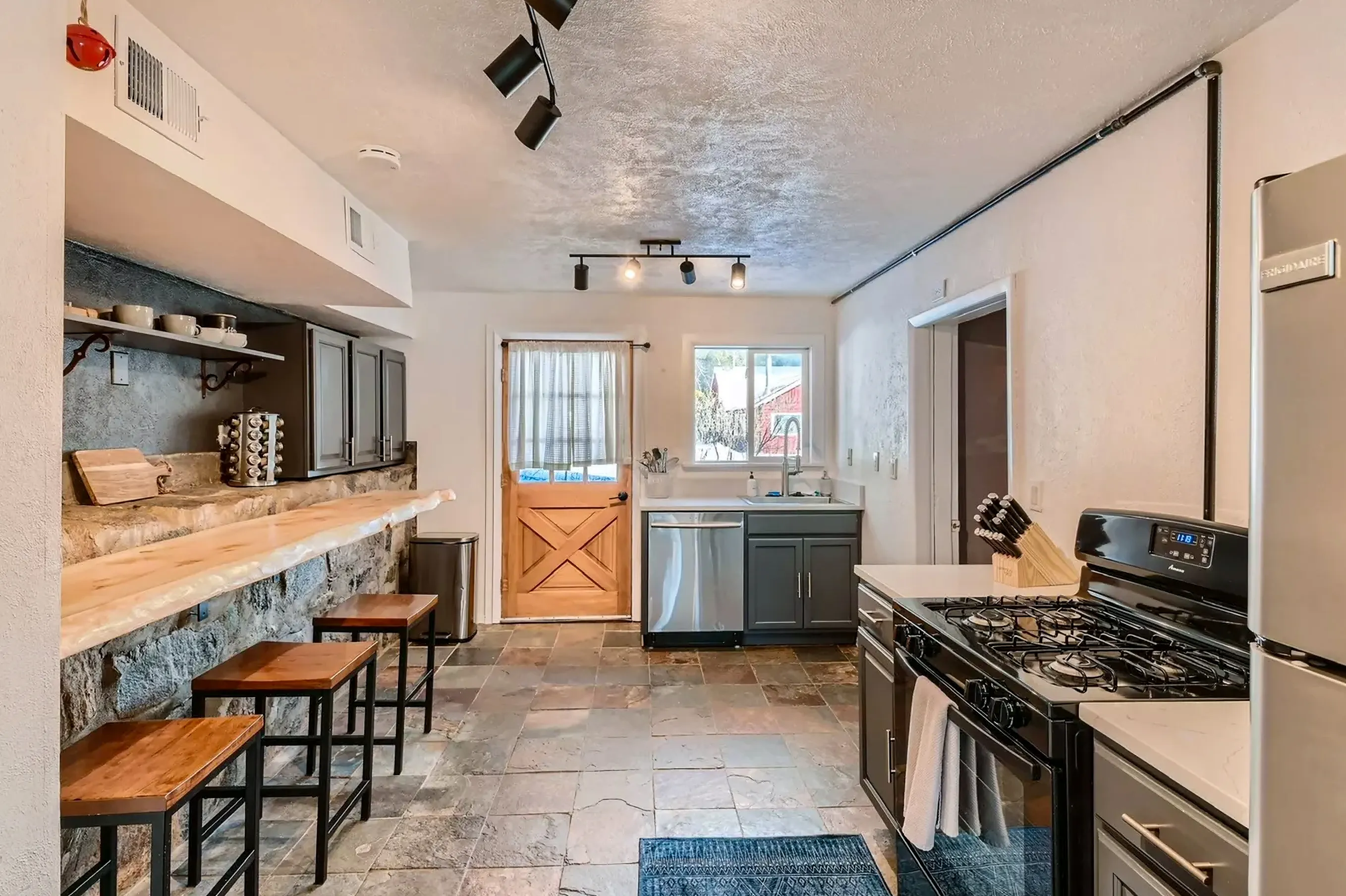 Rustic kitchen featuring a stone bar and natural slate flooring