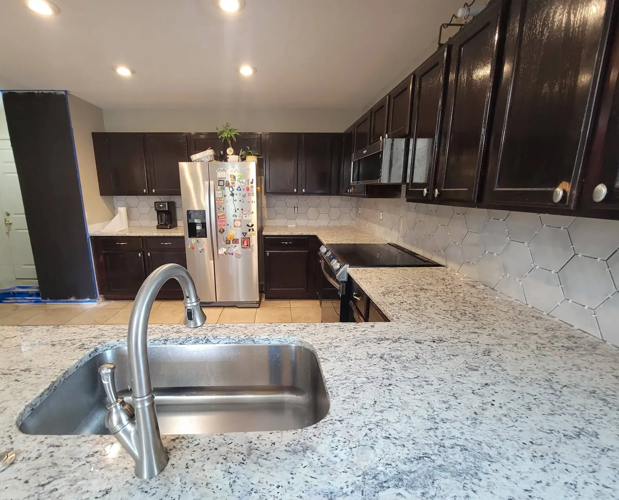 Classic kitchen with dark cabinets and speckled grey granite
