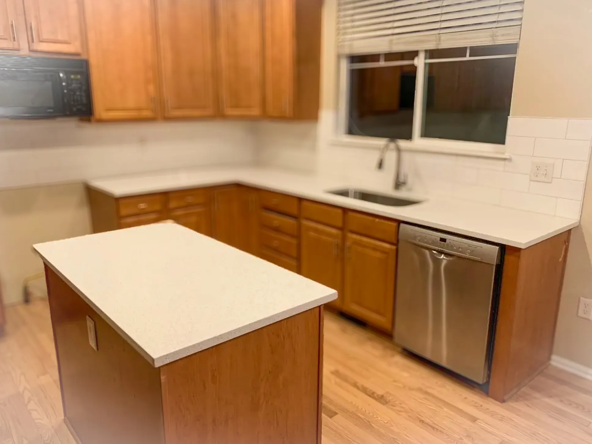 Traditional kitchen with oak-style cabinets and clean white quartz